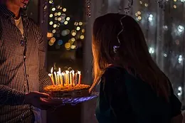 A birthday cake carried to the table