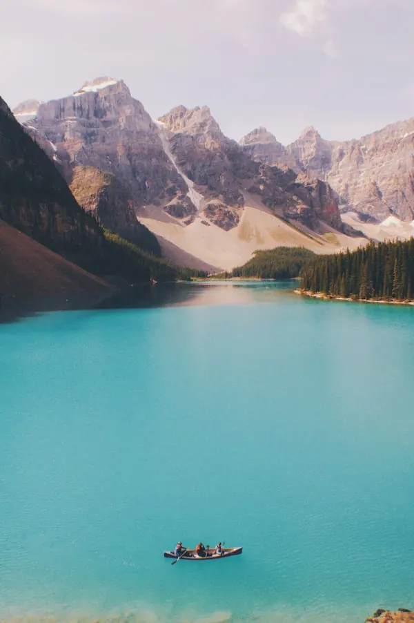 A canoe crossing a turquoise mountain lake