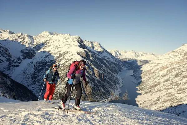 A group of skiers pausing above a mountain valley