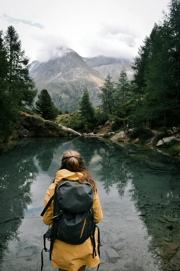 Hiker with a backpack pausing at an alpine lake