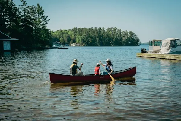 Family paddling a red canoe together