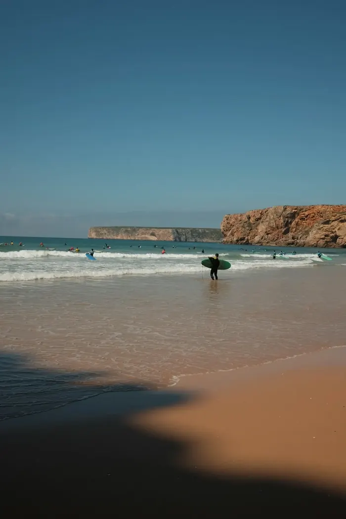 Cliffs and surfers along the Algarve coastline
