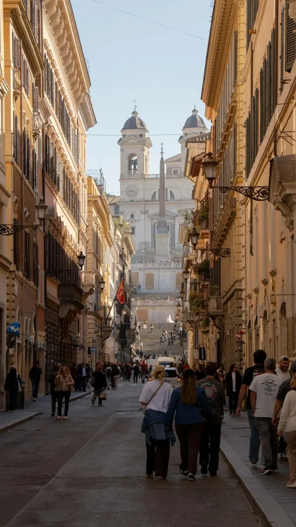 People walking toward a church down a sunlit street