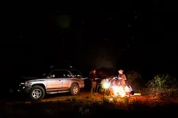 A lit tent under a night sky full of stars
